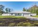 Newly built home with light teal exterior, white fence, and a two-car garage at 14462 Se 28Th Ct, Summerfield, FL 34491