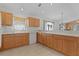 Well-lit kitchen featuring tile floors, bright countertops, and wood cabinets at 1673 Belle Grove Dr, The Villages, FL 32162