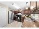 Bright kitchen with stainless steel refrigerator, dark cabinets, and tile flooring at 17006 Sw 39Th Cir, Ocala, FL 34473