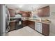 Well-lit kitchen featuring stainless steel appliances and brown cabinets at 17006 Sw 39Th Cir, Ocala, FL 34473