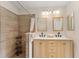 Modern bathroom with double vanity, walk-in shower, and light wood cabinets at 2840 Leicester Ter, The Villages, FL 32162