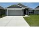 Charming single-story home featuring a gray facade, two-car garage, and well-maintained landscaping at 4445 Sw 90Th Pl, Ocala, FL 34476