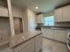 Well-lit kitchen with stainless steel appliances, granite countertops, island and white cabinetry at 4445 Sw 90Th Pl, Ocala, FL 34476