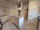 Open kitchen featuring granite countertops, a central island, and white cabinets for a modern touch at 4445 Sw 90Th Pl, Ocala, FL 34476