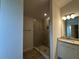 Well lit bathroom featuring a tiled shower with glass door and a vanity with granite countertop and stylish lighting at 4477 Sw 90Th Pl, Ocala, FL 34476