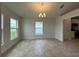 Airy dining room featuring tile flooring, a chandelier, and large windows offering scenic views at 4477 Sw 90Th Pl, Ocala, FL 34476