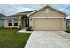 Inviting single-story home with a neutral-colored facade, well-manicured lawn, and attached two-car garage at 4477 Sw 90Th Pl, Ocala, FL 34476