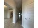 Bright hallway with tile flooring leading to a kitchen and open living area bathed in natural light at 4477 Sw 90Th Pl, Ocala, FL 34476