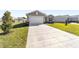 Newly built home with a large driveway and grassy lawn at 7772 Sw 56Th Pl, Ocala, FL 34474