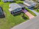 Aerial view of the property highlighting the long driveway, lush lawn, and nearby community at 816 Hibiscus Dr, The Villages, FL 32159