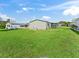 Spacious backyard with green grass, showcasing the home's exterior and outdoor surroundings at 816 Hibiscus Dr, The Villages, FL 32159