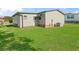 View of the rear of the property, showcasing the well-maintained lawn and siding at 816 Hibiscus Dr, The Villages, FL 32159