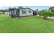 Single-wide manufactured home with a screened porch and landscaped lawn at 816 Hibiscus Dr, The Villages, FL 32159