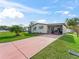 Single-wide manufactured home with carport and well-manicured lawn at 816 Hibiscus Dr, The Villages, FL 32159