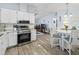 Modern kitchen open to the living spaces with stainless appliances and white cabinetry at 816 Hibiscus Dr, The Villages, FL 32159