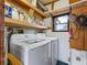 Functional laundry room equipped with a washer, dryer, and ample storage shelving at 816 Hibiscus Dr, The Villages, FL 32159