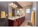 Bathroom features double sinks, dark brown cabinets, a large mirror, and modern lighting at 9257 Sw 94Th Loop, Ocala, FL 34481