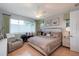 Bedroom features a ceiling fan, large window, dresser, and accent chair at 9257 Sw 94Th Loop, Ocala, FL 34481