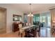 Elegant dining room with glass-top table, chandelier, and view of backyard at 9257 Sw 94Th Loop, Ocala, FL 34481