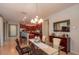 Elegant dining room with a glass-top table, modern chandelier, and access to the kitchen at 9257 Sw 94Th Loop, Ocala, FL 34481