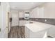 Modern U-shaped kitchen with white cabinets and gray backsplash at 10218 Sw 99Th Ln, Ocala, FL 34481