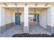 Covered front porch with teal door and lantern lighting at 10832 Sw 101St Loop, Ocala, FL 34481