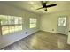 An interior bedroom featuring laminate floors, two windows, and a ceiling fan at 21111 Se Honeysuckle St, Dunnellon, FL 34431