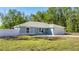 Newly built home with light blue exterior, white fence, and attached garage at 28 Pecan Run, Ocala, FL 34472