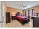 Spacious bedroom with dark wood furniture and a ceiling fan at 451 Hickory Course Loop, Ocala, FL 34472