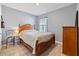 Bright bedroom with wood-like flooring, featuring a wooden bed frame and dresser at 451 Hickory Course Loop, Ocala, FL 34472