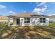 Single story home with covered patio and grassy yard at 451 Hickory Course Loop, Ocala, FL 34472