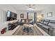 Bright living room featuring leather sofas, a large TV and a ceiling fan at 451 Hickory Course Loop, Ocala, FL 34472