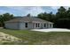 An exterior view showing the back of the house with a lawn and a concrete slab patio at 5489 Nw 12Th. St, Ocala, FL 34482