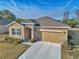 Tan house with gray roof, stone accents, and two-car garage at 6365 Sw 88Th Loop, Ocala, FL 34476