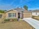 Tan house with gray roof, stone accents, and two-car garage at 6365 Sw 88Th Loop, Ocala, FL 34476