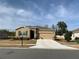 Tan house with stone accents, two-car garage, and landscaped yard at 6365 Sw 88Th Loop, Ocala, FL 34476