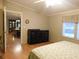 Bedroom featuring a dark dresser, neutral walls, wood floors, and access to another room at 11064 Ne 212Th Ln, Fort Mc Coy, FL 32134