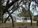 Cozy single-story home with a screened-in porch, nestled among mature trees and lush greenery at 11064 Ne 212Th Ln, Fort Mc Coy, FL 32134