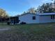 Exterior view of the home with screened-in porch and metal roof at 11064 Ne 212Th Ln, Fort Mc Coy, FL 32134