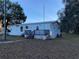 View of the home's exterior showing a small porch with wood railing at 11064 Ne 212Th Ln, Fort Mc Coy, FL 32134