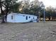 View of the exterior of a cozy home with a small deck and a well-maintained yard at 11064 Ne 212Th Ln, Fort Mc Coy, FL 32134