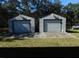 Two detached garages with white roll-up doors, providing ample parking and storage space on property at 11064 Ne 212Th Ln, Fort Mc Coy, FL 32134