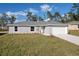 Newly built single-story house featuring gray siding, a white garage door, and a neat lawn at 13351 Sw 83Rd Cir, Ocala, FL 34473