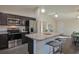 Modern kitchen with dark cabinetry, stainless steel appliances, and an island with seating at 13351 Sw 83Rd Cir, Ocala, FL 34473