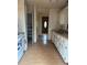 Functional kitchen with white cabinetry, laminate counters, and access to a pantry and the home's front door at 16510 Se 49Th Street Road, Ocklawaha, FL 32179