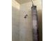 Shower with a shower head and marble-tiled wall and a wood-patterned shower curtain at 16510 Se 49Th Street Road, Ocklawaha, FL 32179