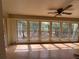 Bright sunroom featuring large windows offering views of the surrounding outdoor space, and a ceiling fan at 16510 Se 49Th Street Road, Ocklawaha, FL 32179