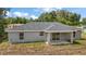 View of backyard featuring gray home with sliding glass doors to covered porch at 174 Pine Crse, Ocala, FL 34472