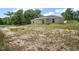 Back exterior of gray home with windows, sliding glass doors to covered porch, and grassy lot at 174 Pine Crse, Ocala, FL 34472