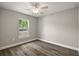 Bright bedroom features wood-look floors, ceiling fan, and a large window providing natural light at 174 Pine Crse, Ocala, FL 34472